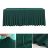 A dark green stretch rectangle tablecloth draped over a table, showing close-ups of the fabric texture.