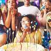 A group of people celebrating a birthday with candles on a cake.
