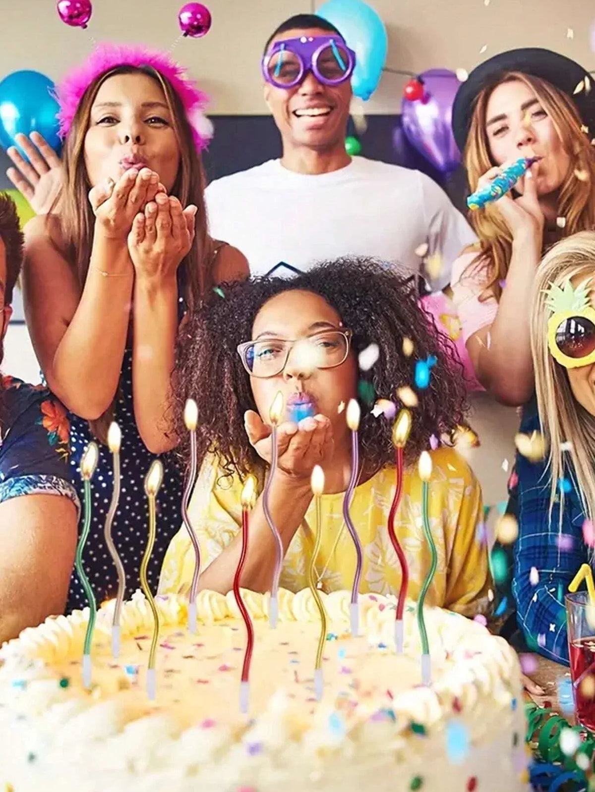 A group of people celebrating a birthday with candles on a cake.