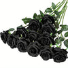 Un ramo de rosas artificiales de seda negra realistas con hojas verdes.