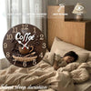 A round wooden wall clock with a coffee theme featuring a steaming cup and coffee beans, displayed on a bedside table.