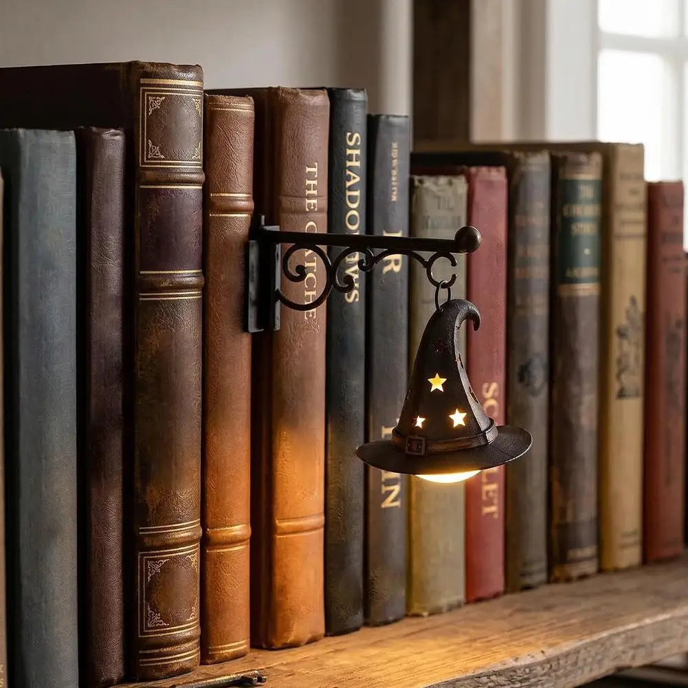 A collection of old leather-bound books displayed on a wooden shelf, illuminated by a decorative lamp.