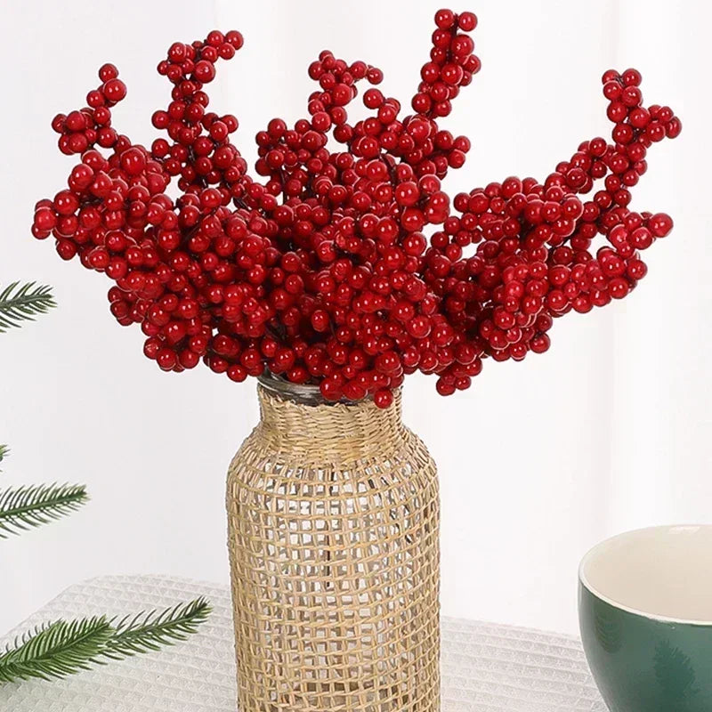A vase filled with artificial red holly berry stems used for Christmas decor.