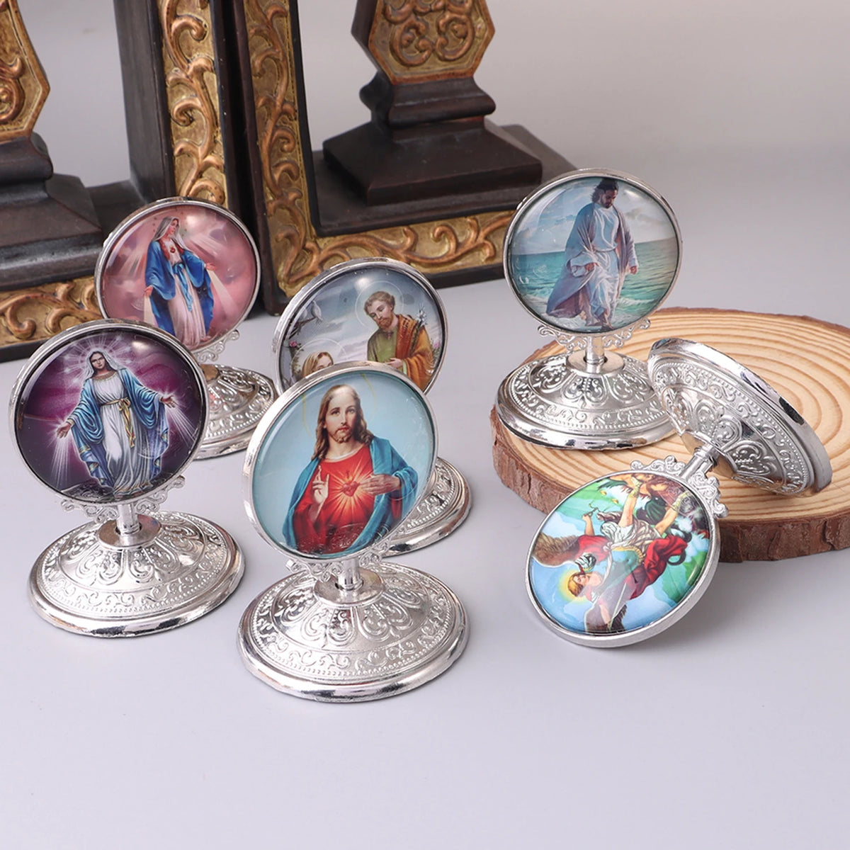 A collection of vintage silver-framed Catholic tabletop ornaments featuring religious figures like Jesus and Mary.