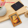 A wooden cutting board shows a gold-framed picture of an orange cat eating pizza and a black magnet with the text back is ful