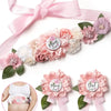 Pink floral maternity sash and corsage pin set with a bow for a baby shower