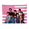 A group of seven young men posing in front of a pink and white striped American flag background.