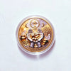 A round gold commemorative coin featuring the Eye of Providence, hands holding gold coins, and a tree, set in a clear plastic