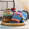 A set of ten vintage cotton drawstring gift pouches in various colorful patterns displayed on a wooden tray.