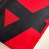 Primer plano de un diseño diagonal rojo y negro en una tela tapiz.