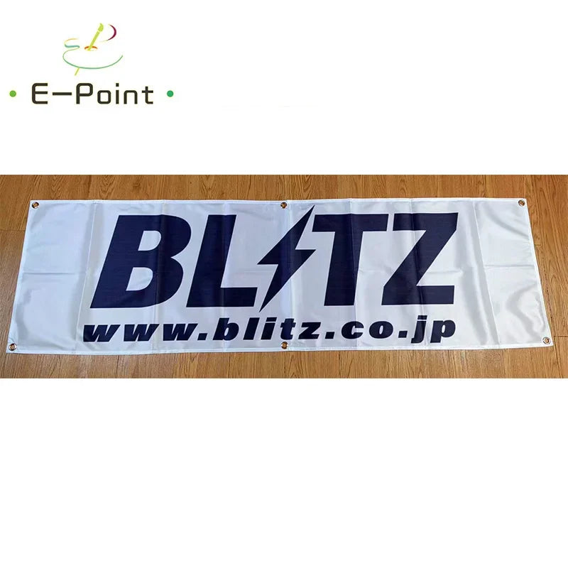 A white double-sided polyester banner featuring the text BLITZ with a lightning bolt design and the website www.blitz.co.jp