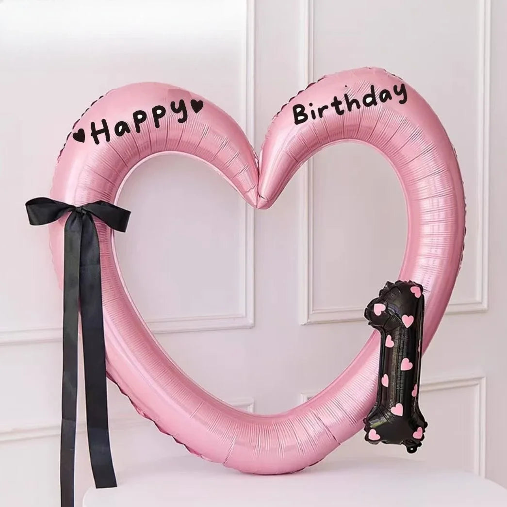 Pink heart-shaped balloon decoration with Happy and Birthday text on it