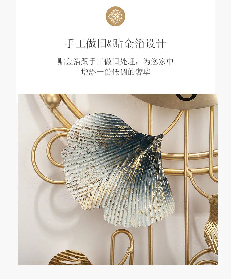 A close-up of a decorative metal ginkgo leaf wall clock with gold accents, featuring textured silver and blue tones.