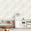 A white wooden bed is set against a wall covered in boho floral peel and stick wallpaper.
