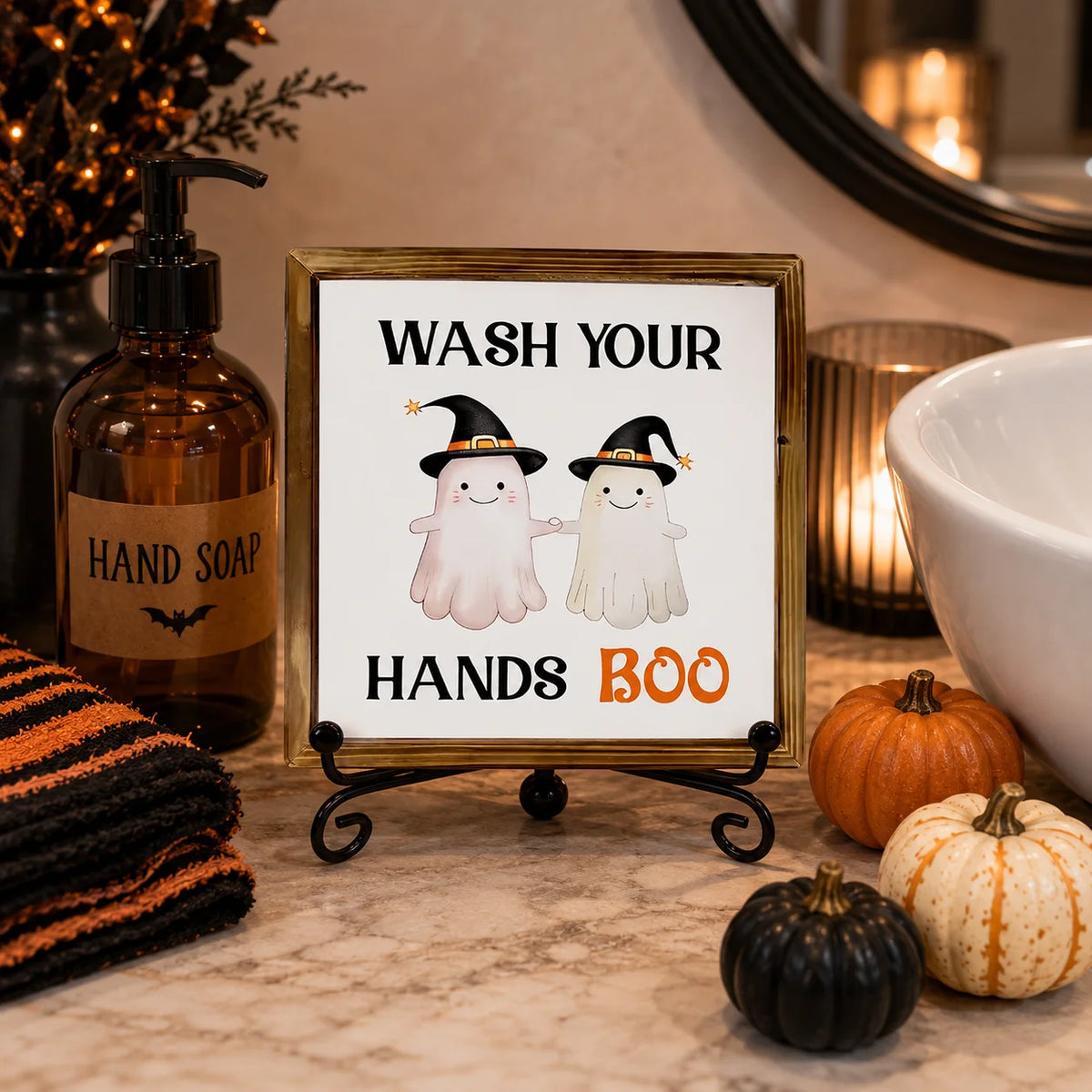 A framed sign featuring two white ghost figures with witch hats for Halloween bathroom decor