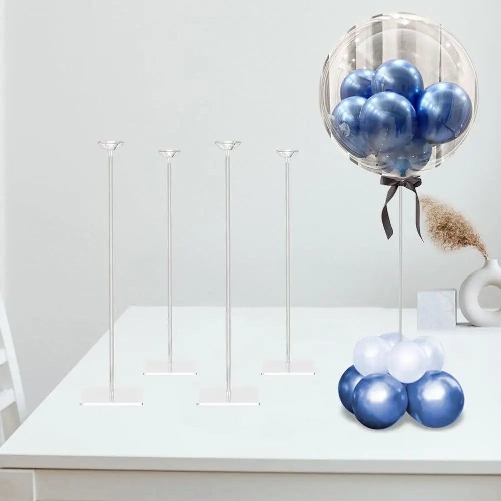 A clear acrylic balloon stand kit with four blue and white balloons displayed on a white table.