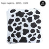 A stack of 20 black and white cow print paper napkins.