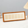 A wooden photo frame display stand with six rectangular panels set in a light wood background.