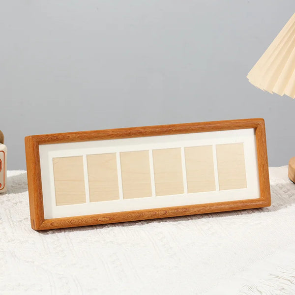 A wooden photo frame display stand with six rectangular panels set in a light wood background.