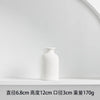A white ceramic tabletop vase with a smooth, rounded shape is displayed on a white shelf.