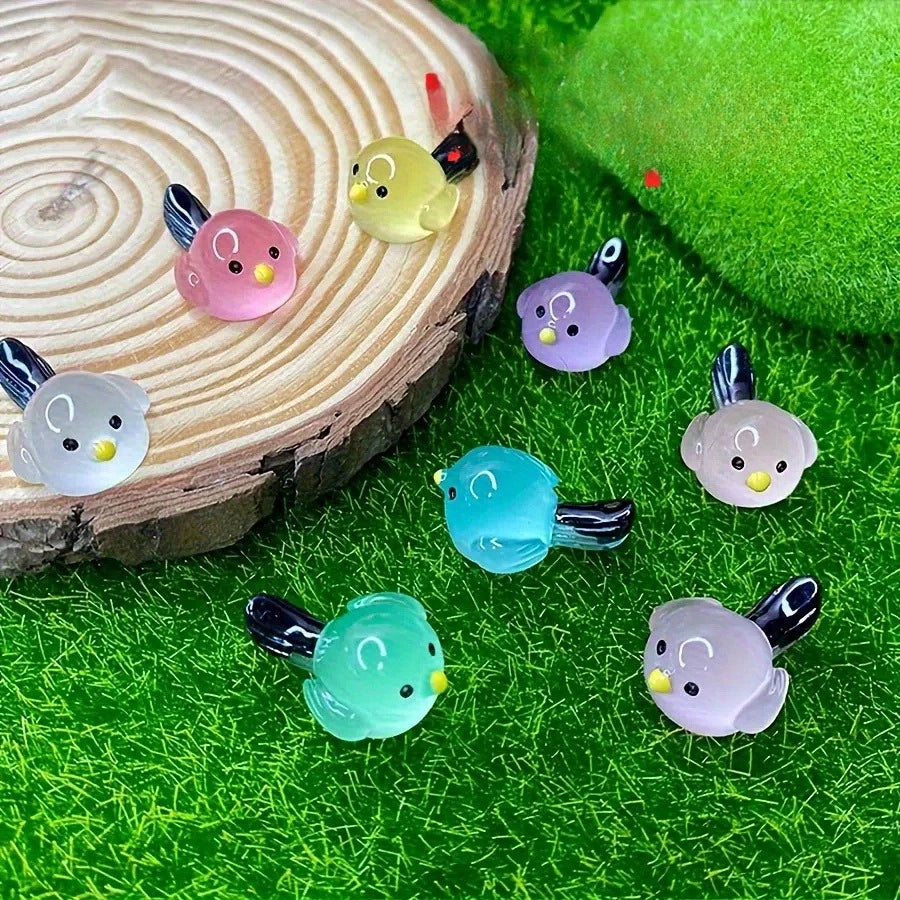 A set of mini luminous resin bird fairy garden decor featuring various colored birds on a green textured surface.