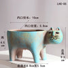A light blue ceramic cat planter with a long opening, showing dimensions for indoor plant use.
