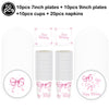A set of pink bow disposable party tableware including 7 inch and 9 inch plates, cups, and napkins.