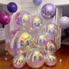 A collection of ten iridescent metallic rainbow foil balloons reflecting light in various shades of purple and pink.
