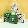 A set of green and white soccer-themed gift bags with a banner and soccer ball patterns displayed on a light surface.