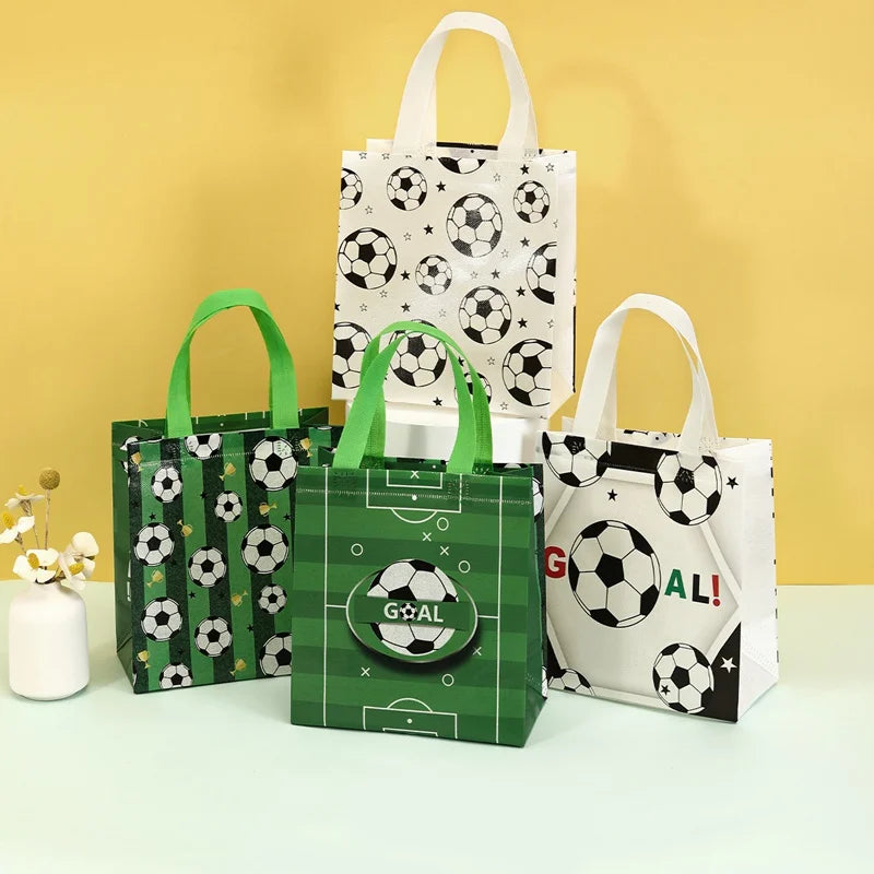 A set of green and white soccer-themed gift bags with a banner and soccer ball patterns displayed on a light surface.