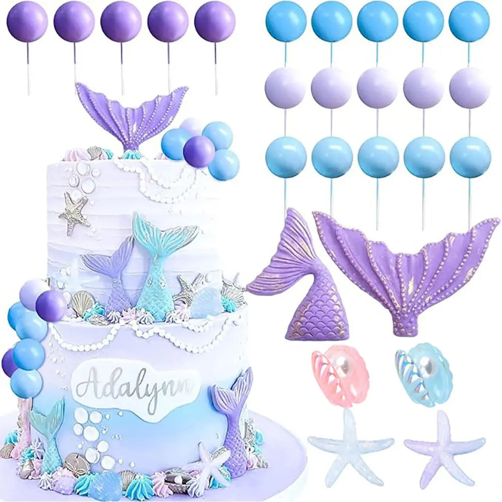 A tiered mermaid cake decorated with purple and blue accents, featuring various sea creature toppers and seashells.