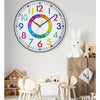 A colorful silent wall clock with numbers 1 to 12 and a decorative rabbit figurine on a wooden shelf.