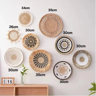 A collection of woven straw wall hangings in various sizes and textures, displayed against a white wall.
