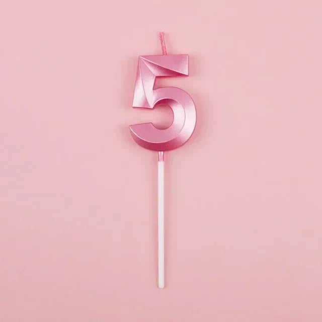 A pink number five candle with a thin white stick against a light pink background.