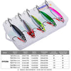 A white storage box holds a set of metal jig fishing lures with various colors and sizes.