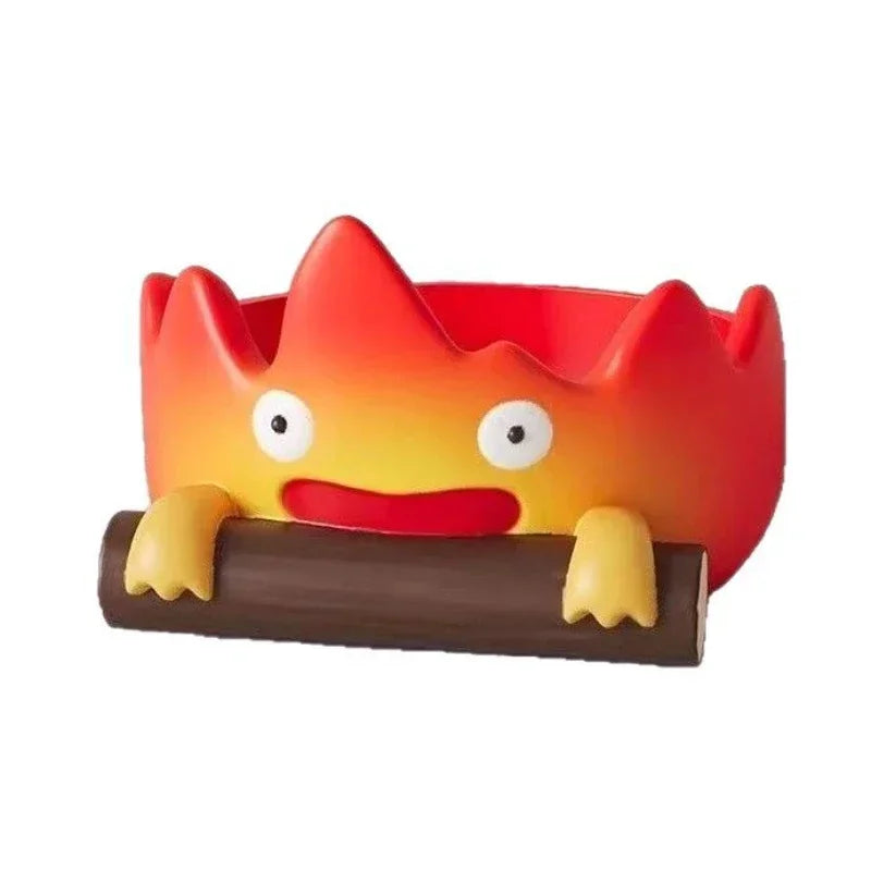 A resin cartoon fire person tray with an orange and red face emerging from a brown base.