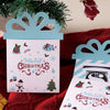 A set of three pink and blue cartoon Christmas thank you cards with festive designs displayed on a red fabric.