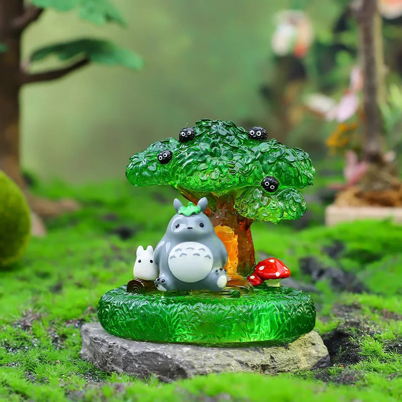 A green ceramic ornament featuring a small gray animal figure with white accents, set in a mossy outdoor scene.