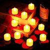 A set of glowing yellow tea light candles placed on a wooden box surrounded by red rose petals.