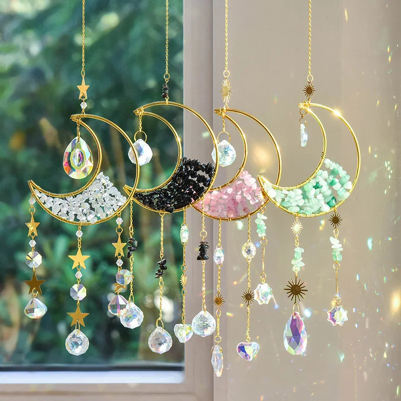 A gold moon suncatcher wind chime featuring various colored glass prisms and charms hanging against a light background.