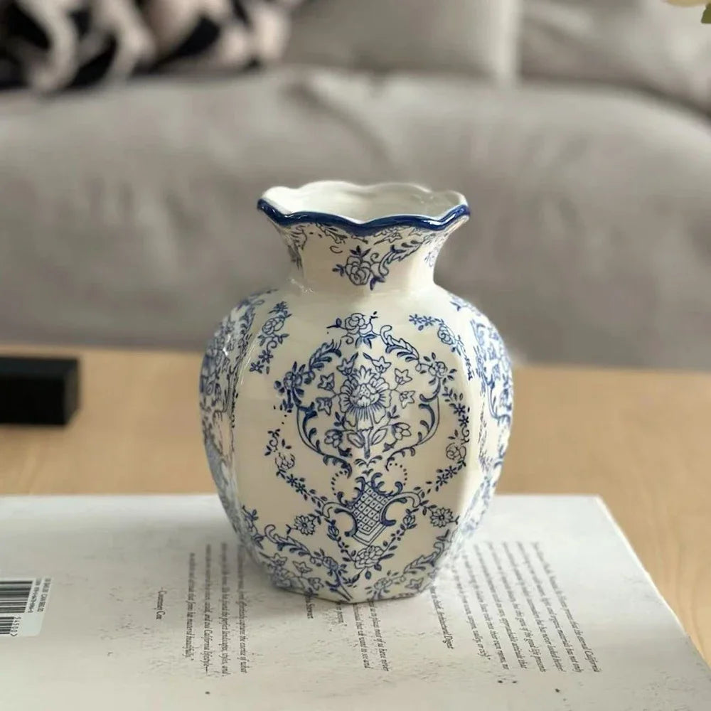 Hand-painted blue and white porcelain vase with a scalloped rim sitting on a light wooden surface.