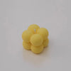 A cluster of yellow soy wax candles, some white and pink, arranged together.