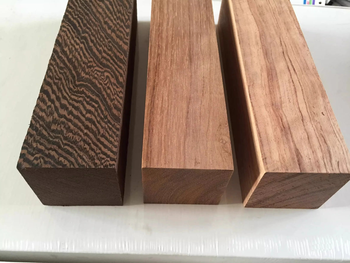 Three rectangular blocks of natural wood blanks for knife handles and DIY projects, showing different grain patterns.