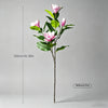 A tall artificial magnolia tree with pink silk flowers displayed against a gray background.