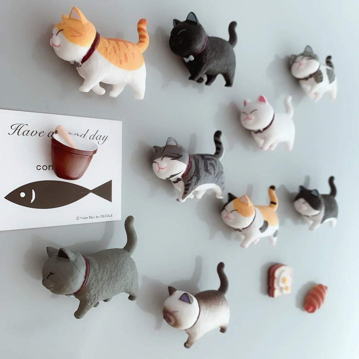 A collection of 3D cartoon cat refrigerator magnets in various colors and poses.