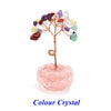 A crystal healing gemstone bonsai featuring various colored crystals growing from a pink quartz base.