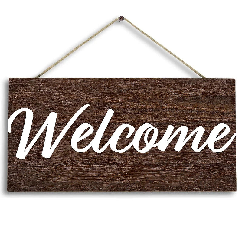 Rustic wooden welcome sign with white script text hanging on a twine