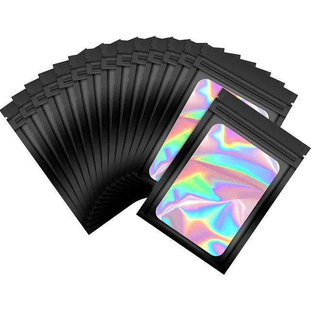 Une pile de sacs de stockage laser ziplock noirs, avec un sac translucide et iridescent visible sur le dessus.