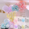 A colorful balloon garland kit featuring pink, blue, and yellow balloons arranged for a birthday decoration.