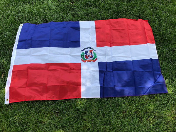 Gran pancarta con la bandera de la República Dominicana, con campos rojos y azules, una cruz blanca y laCoat of Arms